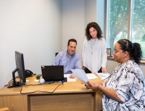 Three UGI employees talking at a desk
