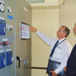 UGI employee with client looking at CHP system control panel