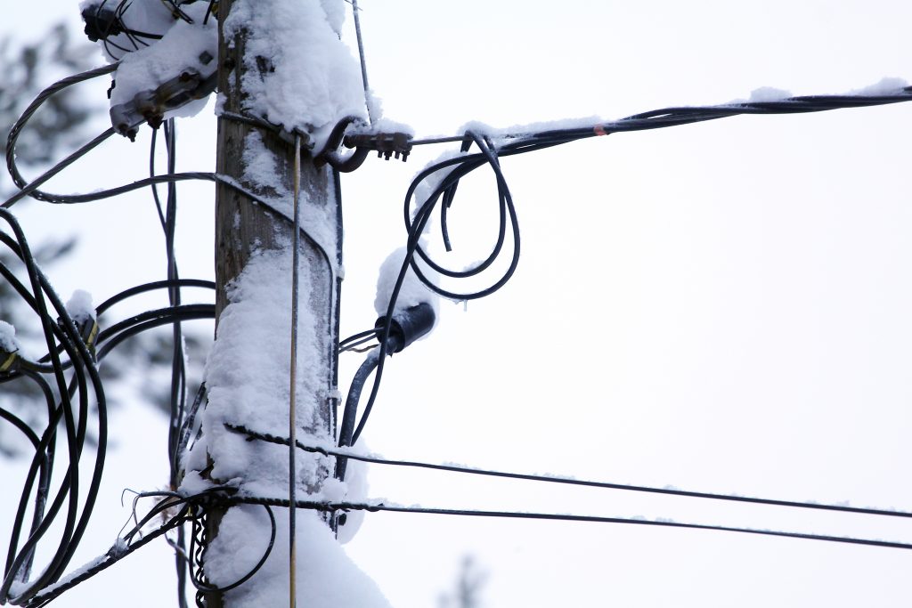 snow covered electric pole and power lines