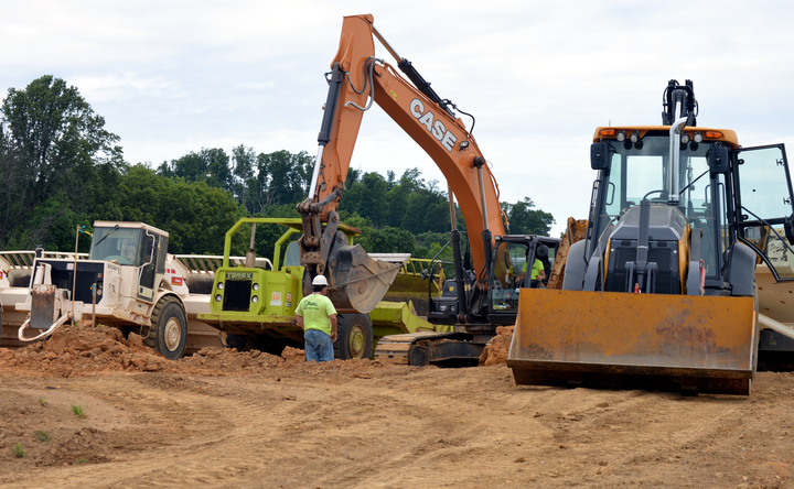 backhoe and bulldozer move dirt