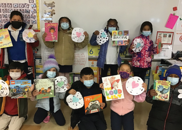 Students posing with books from the RIF book distribution program