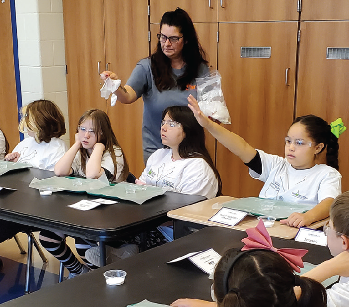 UGI employee at a SPARKS event with students in science gear