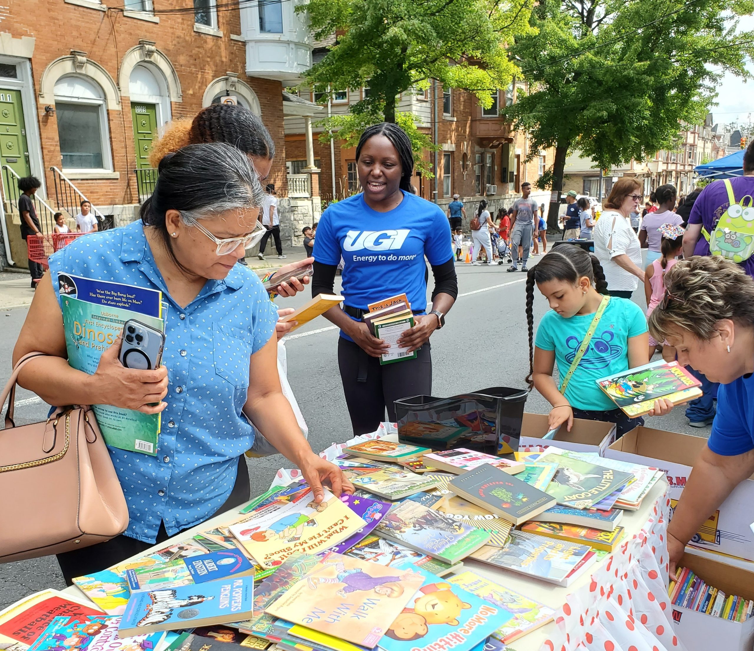 UGI employee hands out books to community members.