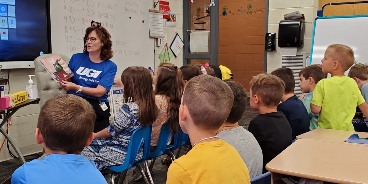 UGI employee reads to a classroom of students.