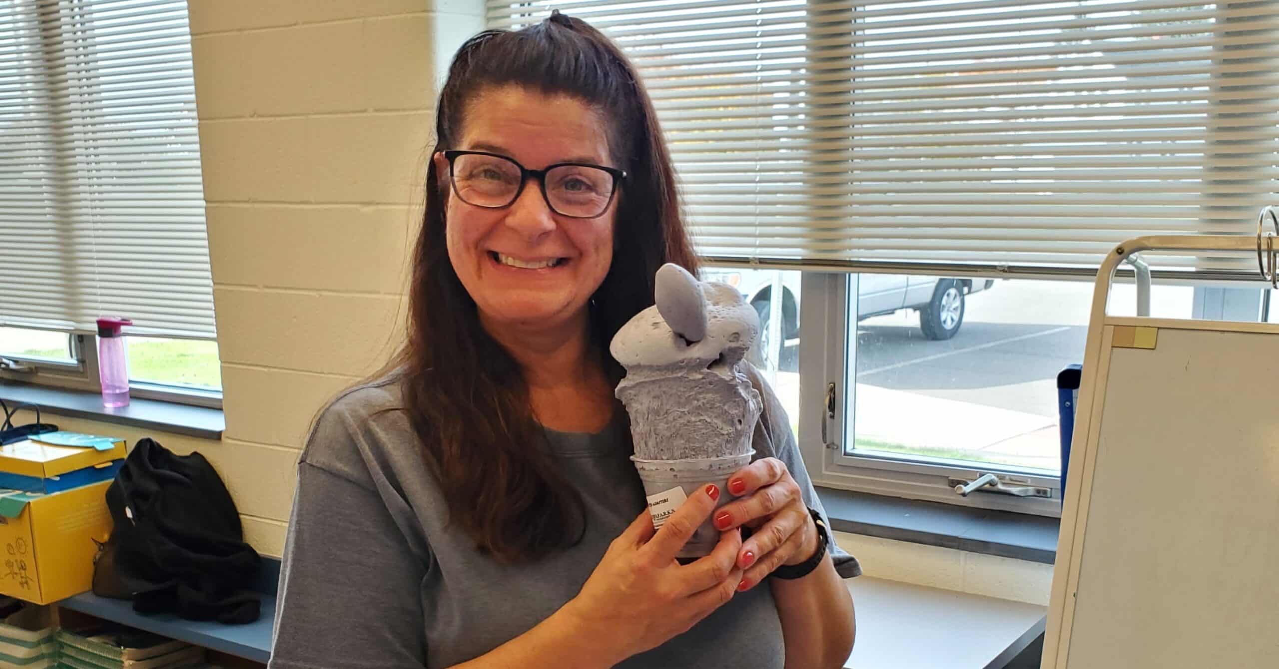 UGI employee holds up science experiment while volunteering in classroom.
