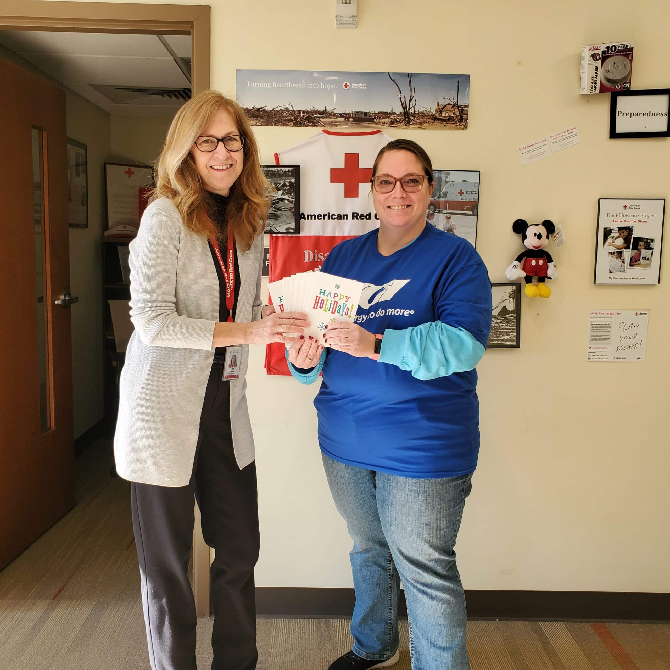 UGI employee hands holiday cards to American Red Cross employee.