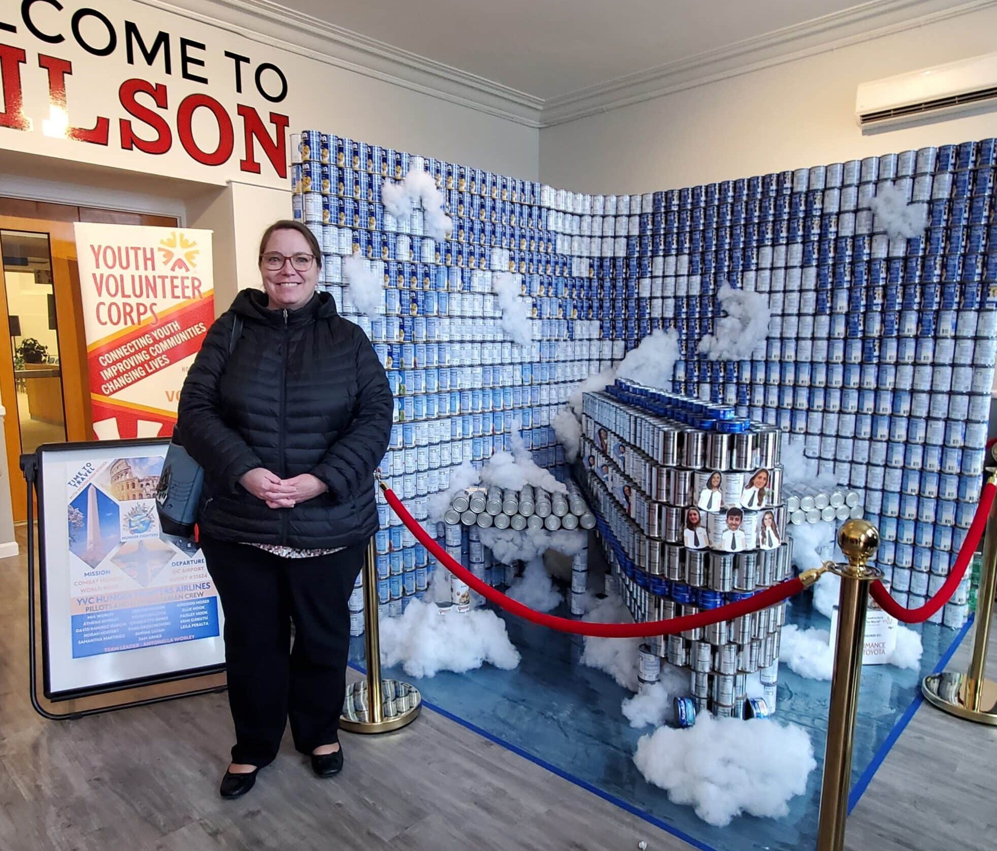 UGI Utilities employee stands in front of airplane sculpture made out of canned food.