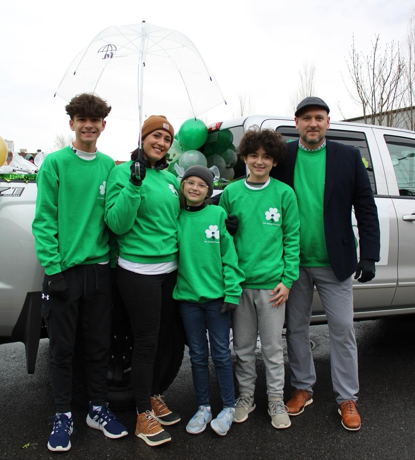 Family smiling together wearing green in support of Mental Health Awareness.