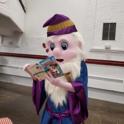 The updated Reading Wizard reading a book.