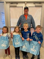 UGI employee stands with first graders who have received their UGI-RIF literacy kits.