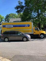 A van parked next to a Penske truck used to deliver books to Lancaster students during COVID.