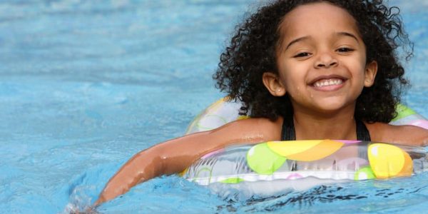 Little girl swimming in pool with natural gas pool heating